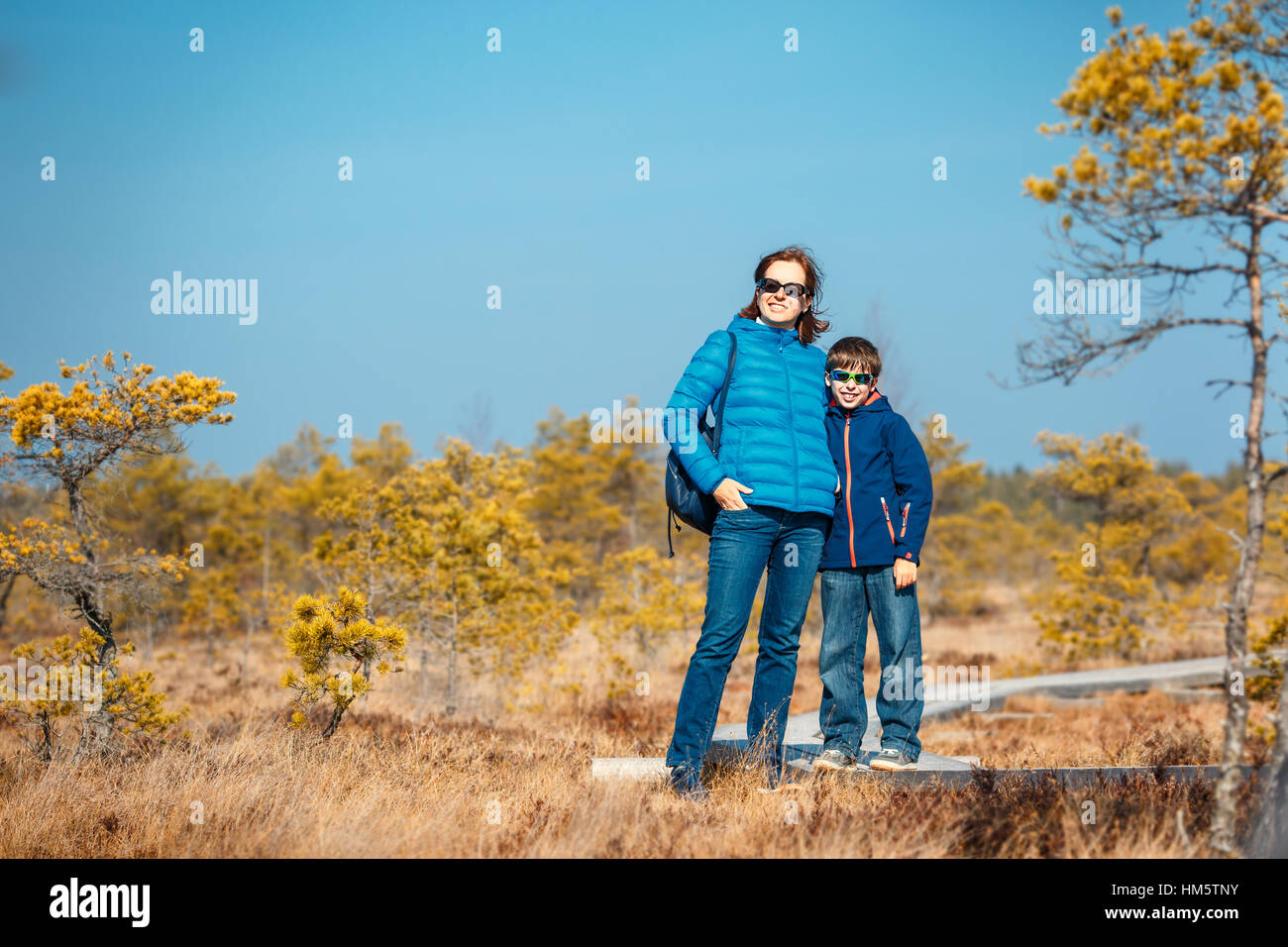 Cute little boy with mother walking on trail in swamp, Kemeri national park, Latvia Stock Photo