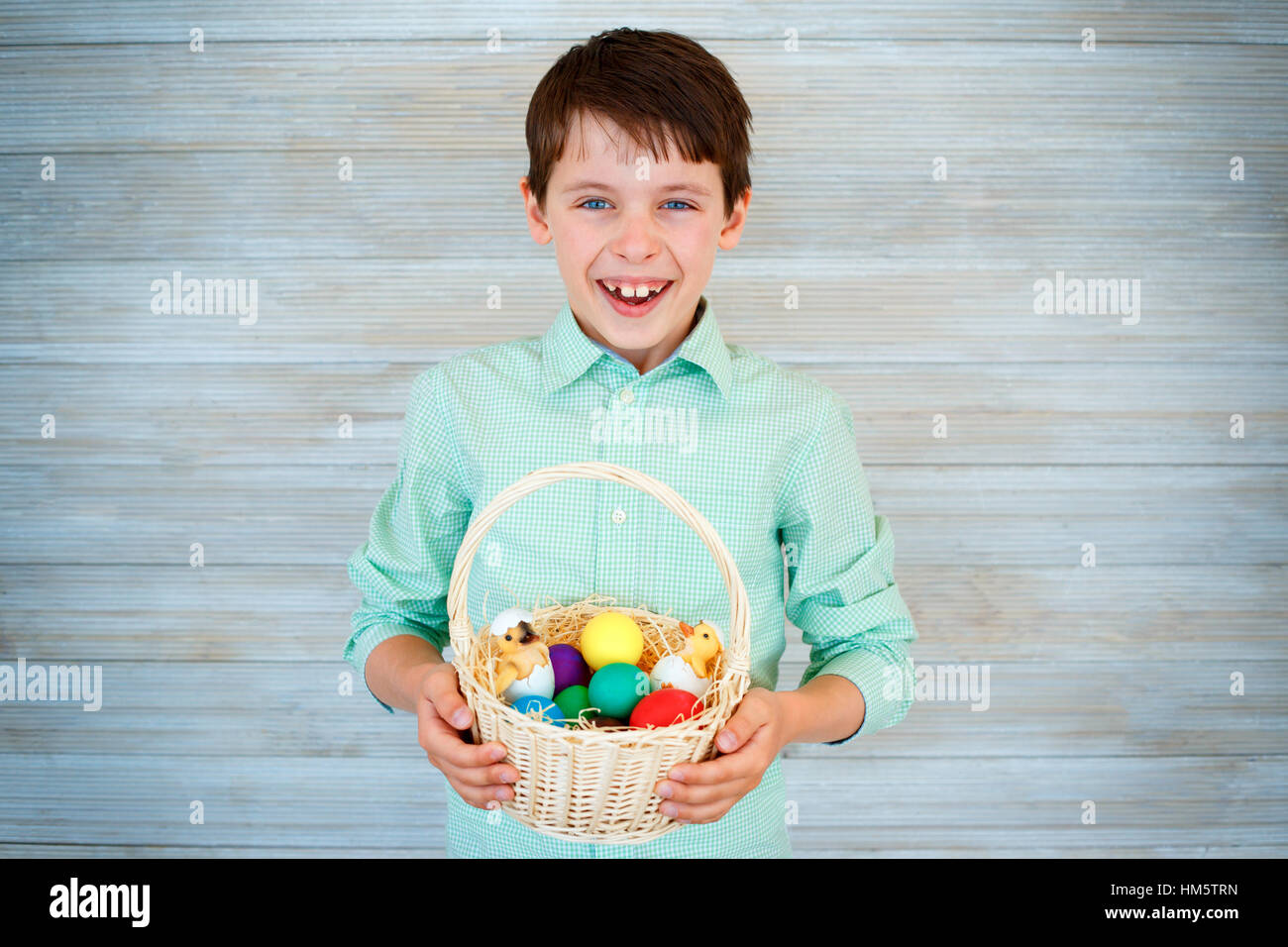 Cute little boy holding basket with colorful eggs after easter egg hunt Stock Photo