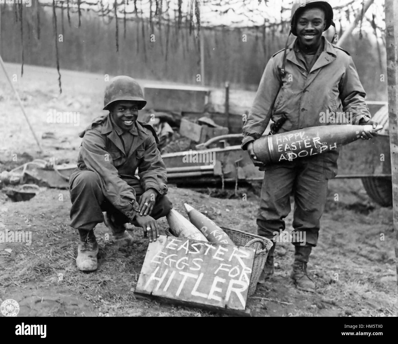 AMERICAN ARTILLERY WW2. Members of the American 33rd Field Artillery Battalion on 10 March 1945 during the Battle of Remagen. Tech Sgt William E. Thomas at left smiles at his handiwork while Private First Class Joseph Jackson holds a shell Stock Photo