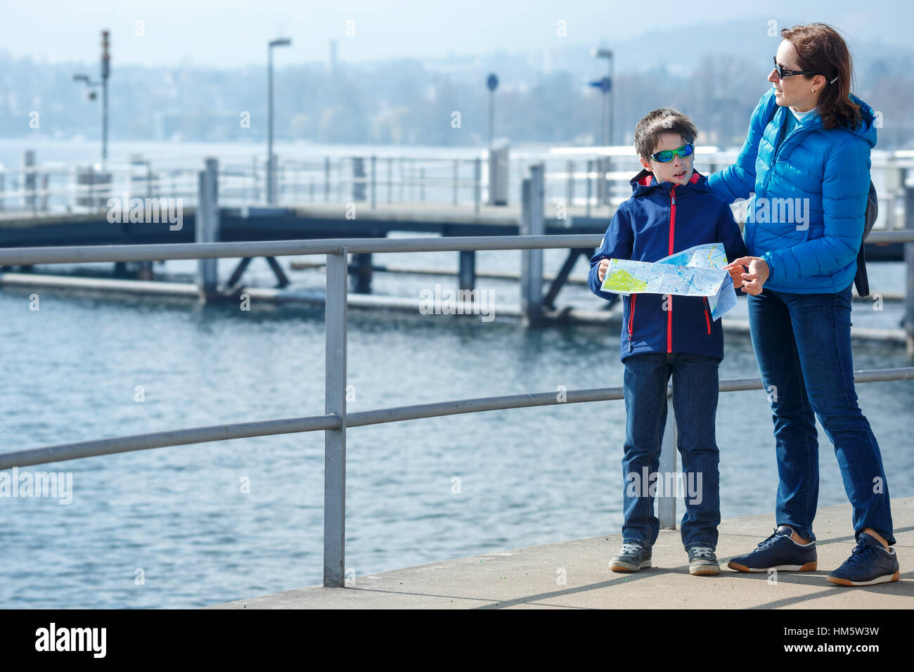 Family of mother and son walking near pier on Lake Zurich Stock Photo