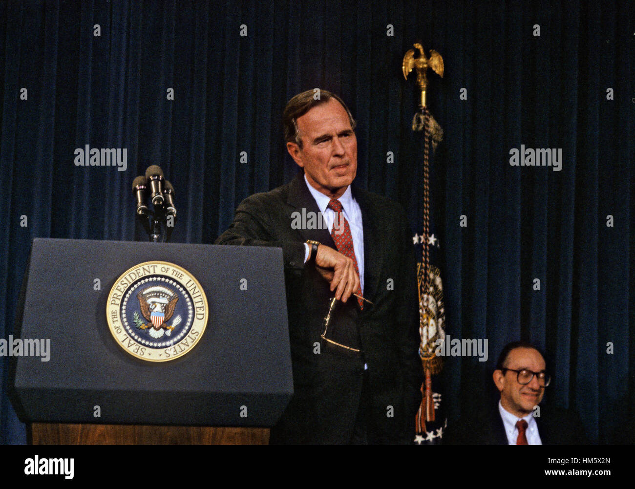 United States President George H.W. Bush announces his savings and loan bailout plan at a press conference at the White House in Washington, D.C. on February 6, 1989. Alan Greenspan, Chairman of the U.S. Federal Reserve looks on from lower right..Credit: Stock Photo