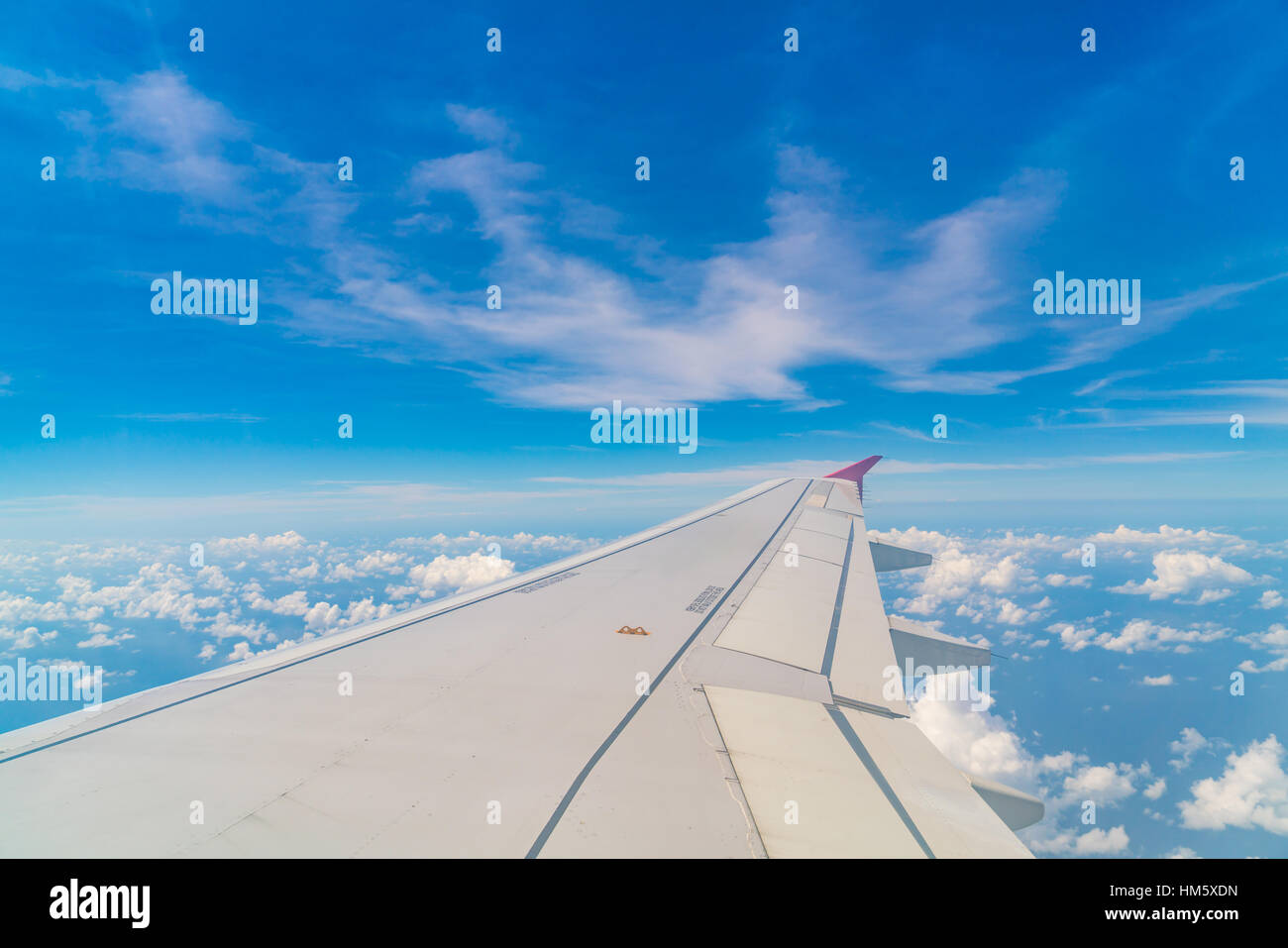 Wing of an airplane flying above the clouds Stock Photo - Alamy