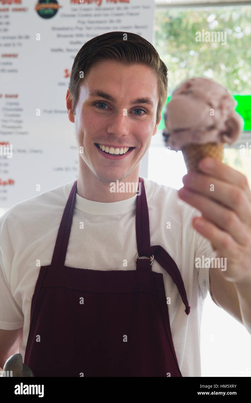 Portrait of sales clerk holding ice cream cone Stock Photo Alamy