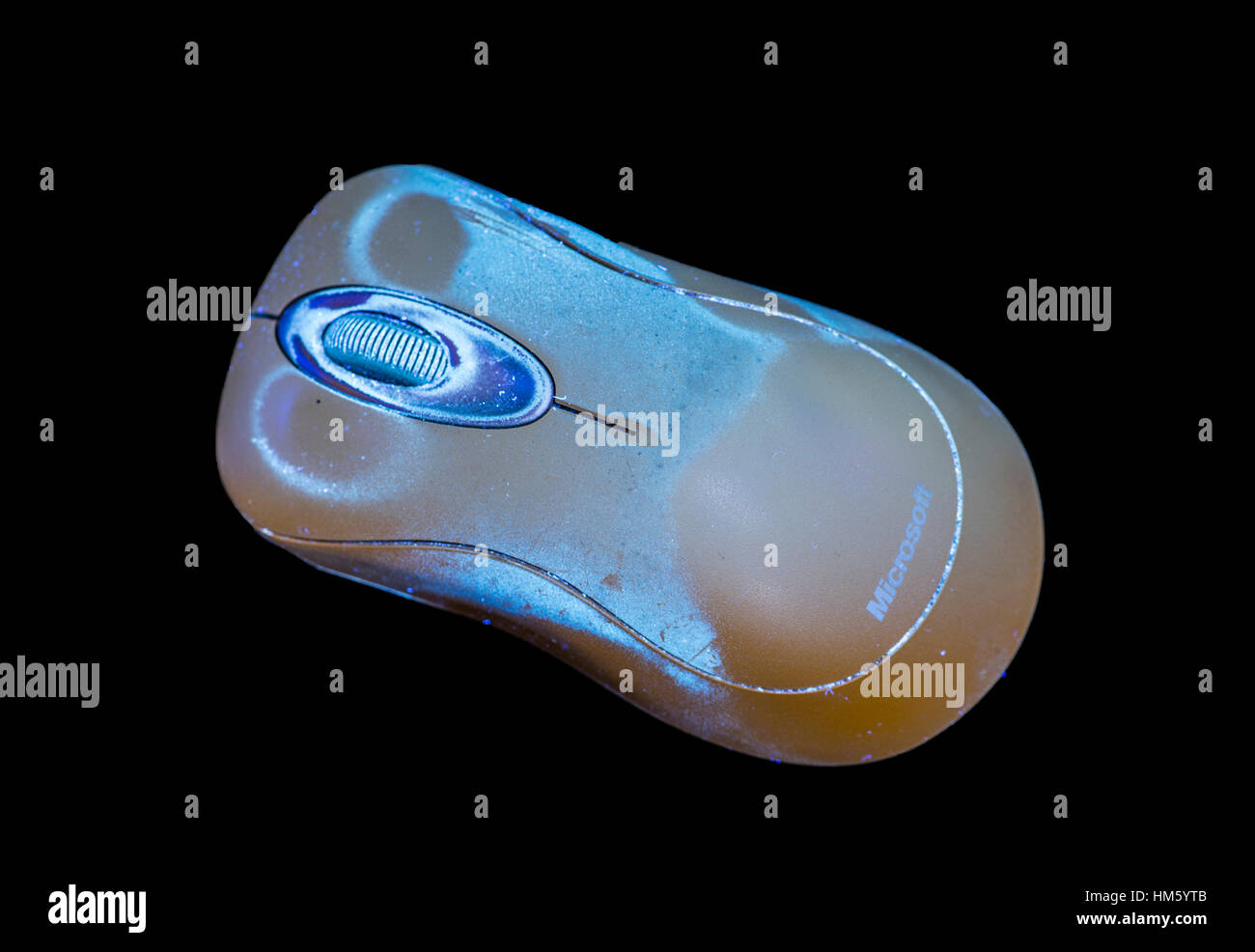 Computer mouse, fluorescing in UV light, showing dirt on surface Stock Photo