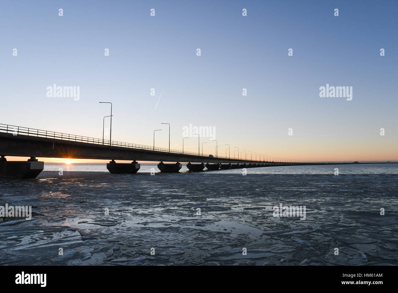 Ice floe and sunset by the Oland bridge connecting the island Oland with mainland Sweden Stock Photo