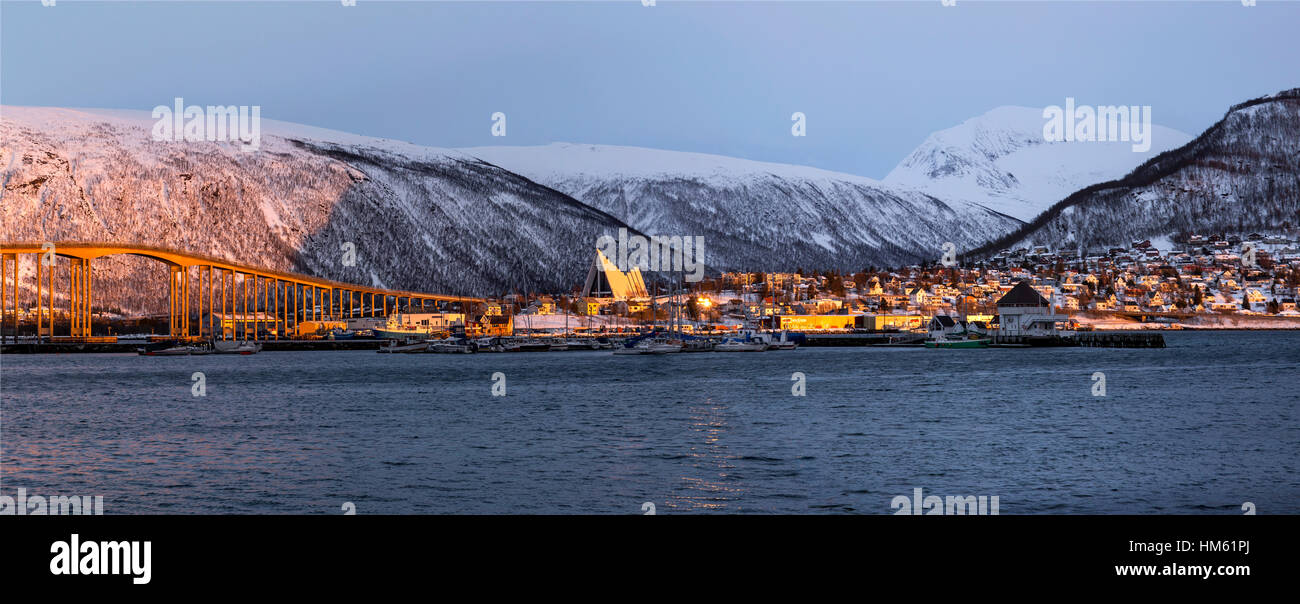 An evening view of the skyline of Tromsø in northern Norway. The Arctic Cathedral is visible along with the bridge that connects to the mainland. Stock Photo