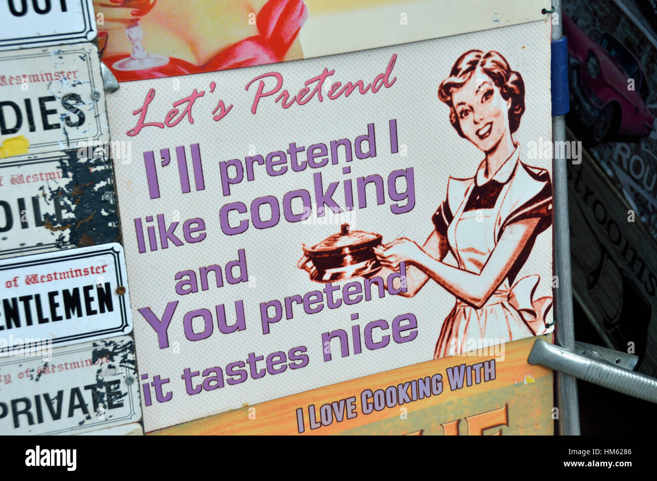 A nineteen fifties tin sign relating to cooking for others Stock Photo
