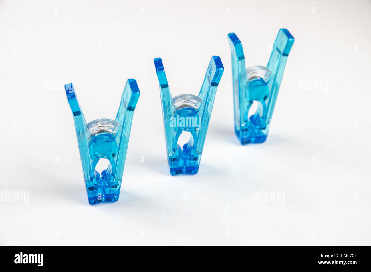 Blue plastic clothespins on white background Stock Photo Alamy