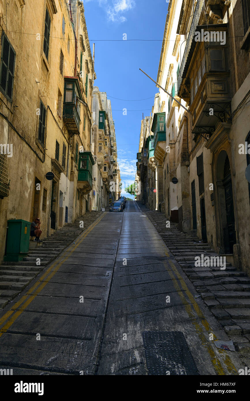 hill hilly side street streets steep straight colourful wooden balcony traditional narrow congested space road Valletta malta Stock Photo