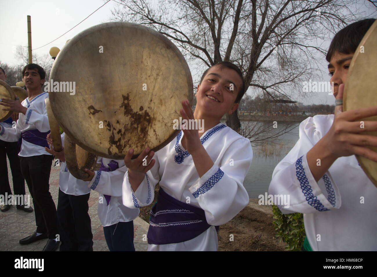 Tajik musicians in national costumes played on the popular percussion instruments Dayereh during a holiday in the Khujand city Stock Photo