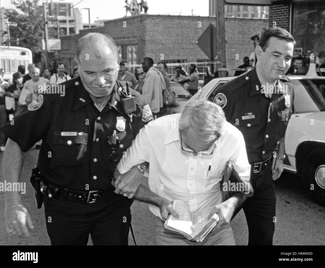 Police arrest a man with his Bible as he is arrested after demonstrating outside an abortion clinic Stock Photo