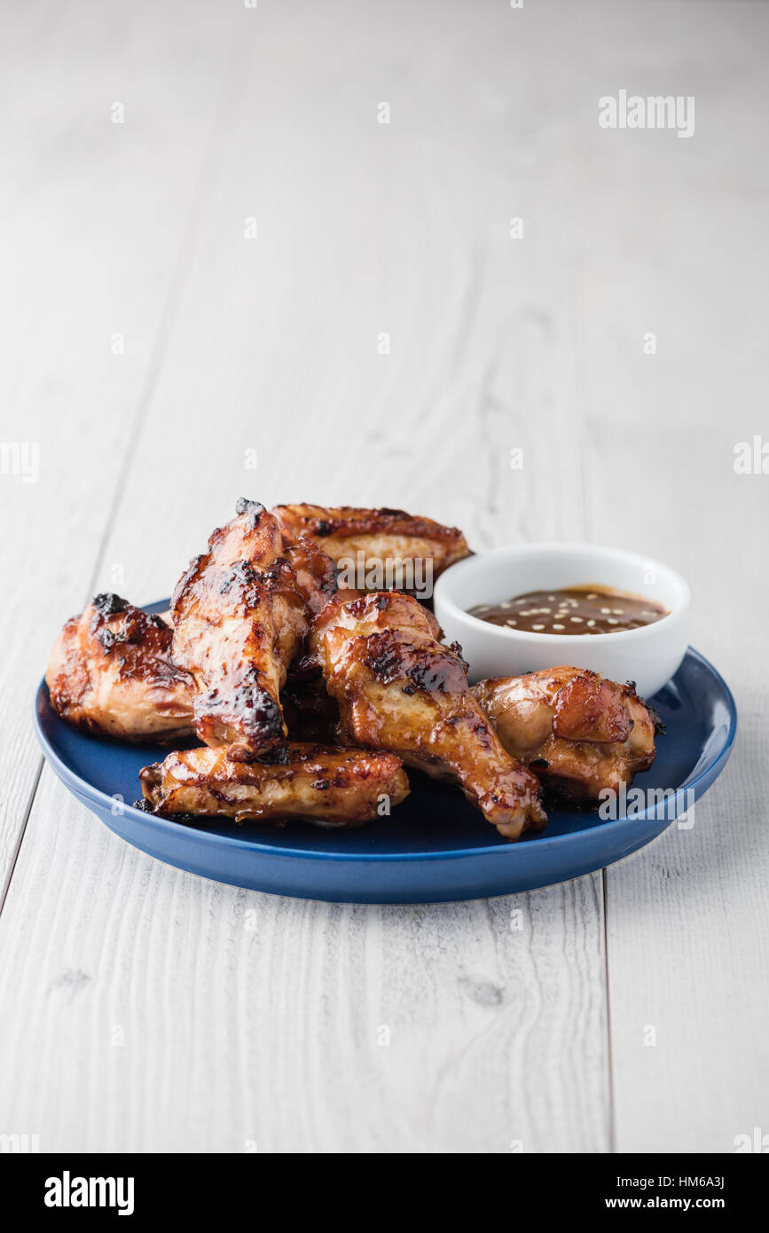 Glazed teriyaki chicken wings with dipping sesame seeds sauce Stock Photo
