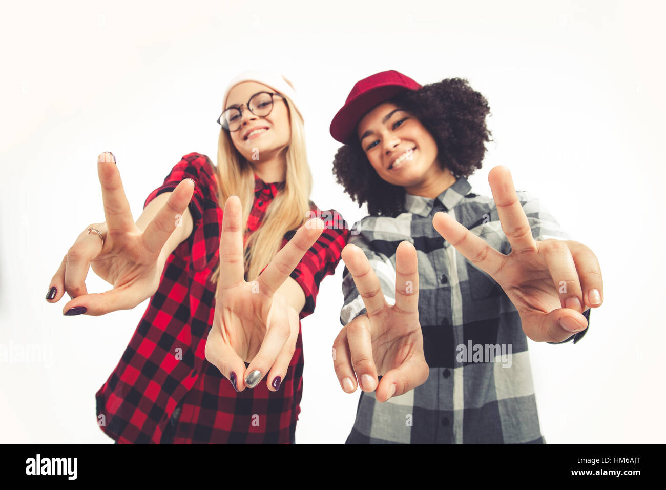 Studio lifestyle portrait of two best friends hipster girls going crazy and having great time together. Isolated on white background. Stock Photo