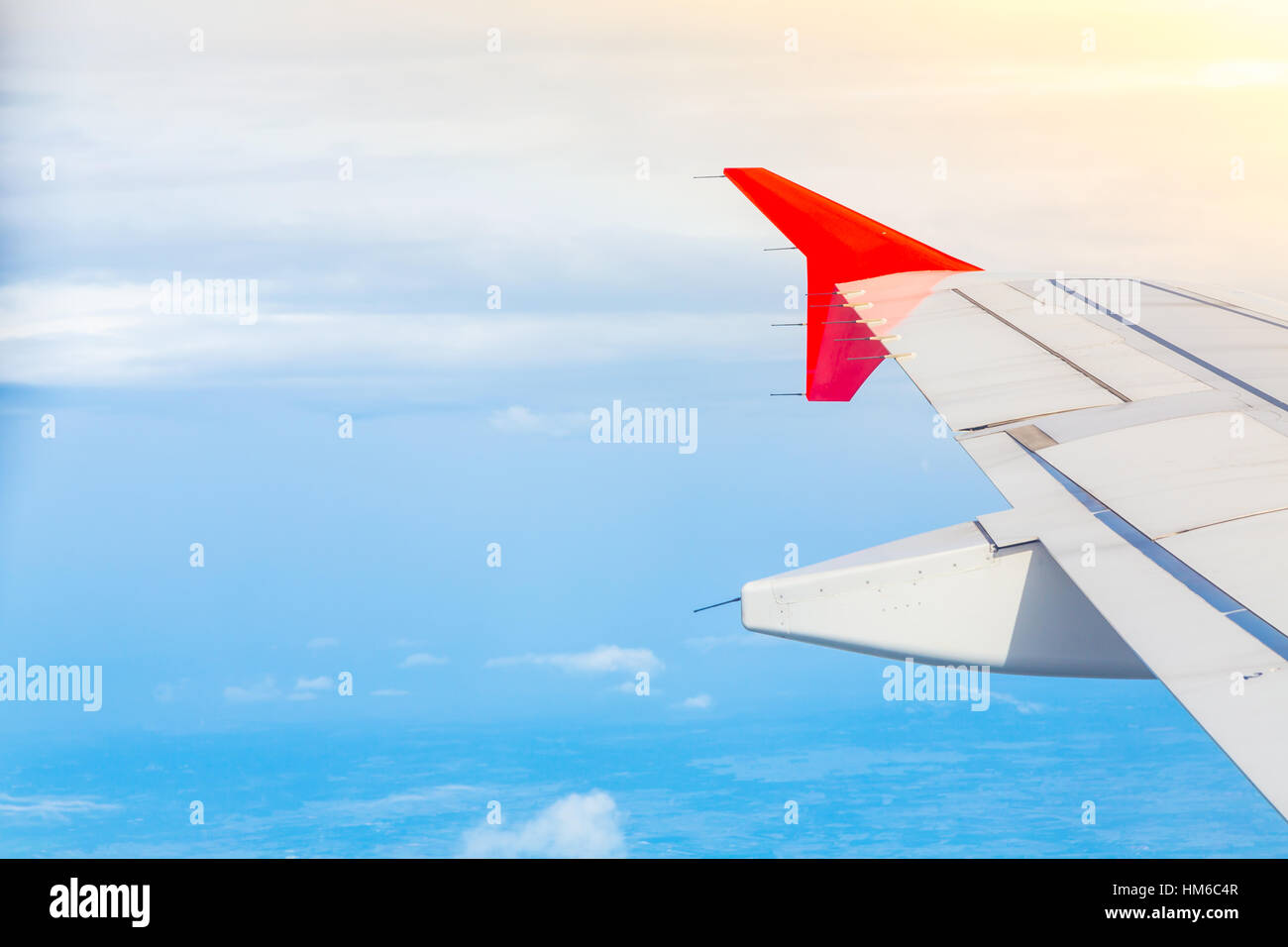 Wing of an airplane flying above the clouds Stock Photo - Alamy