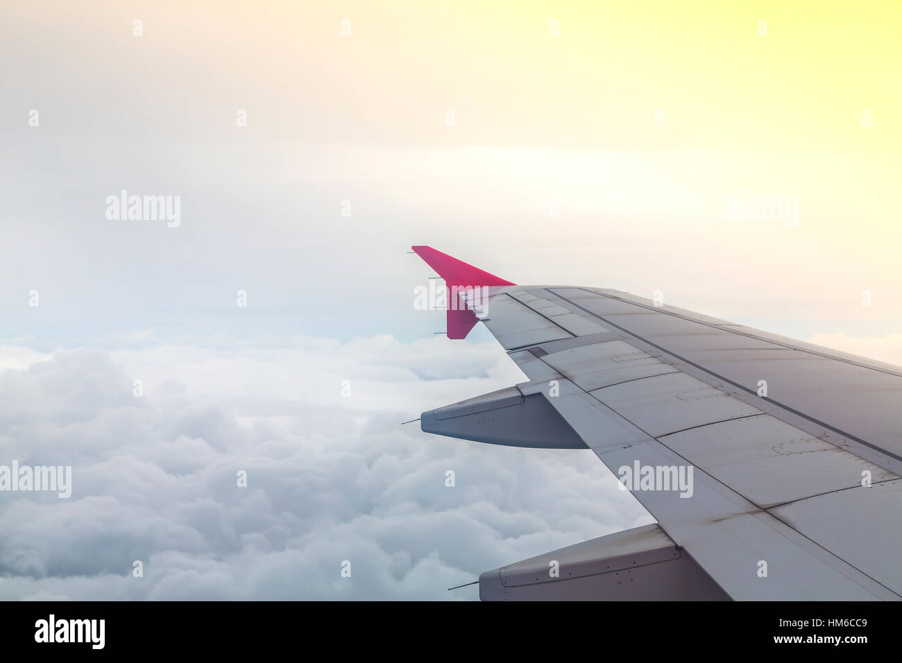 Wing of an airplane flying above the clouds Stock Photo - Alamy