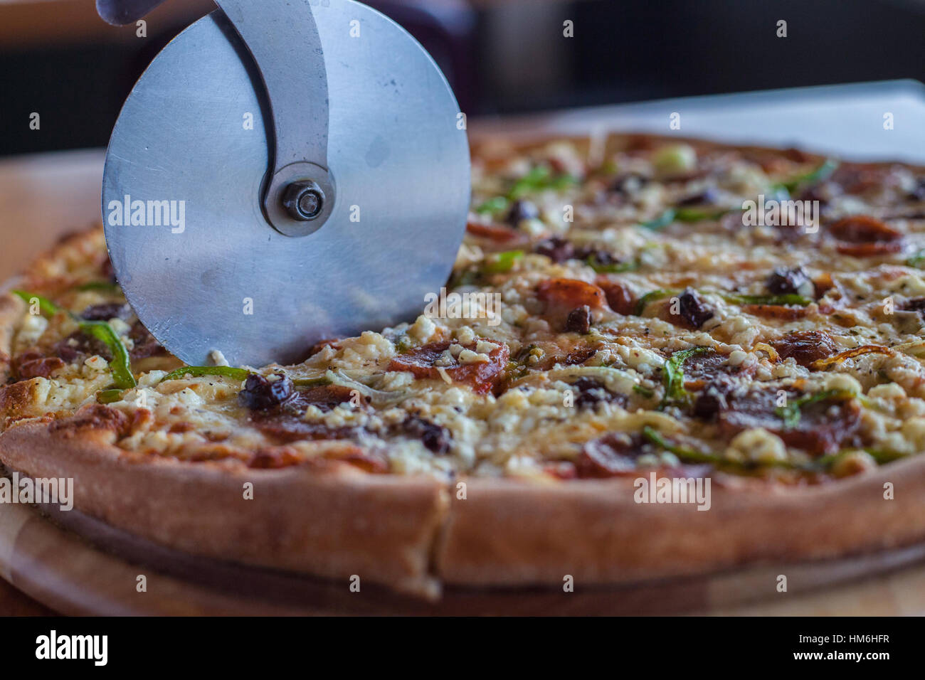 Wheel slicer slices a pizza Stock Photo Alamy