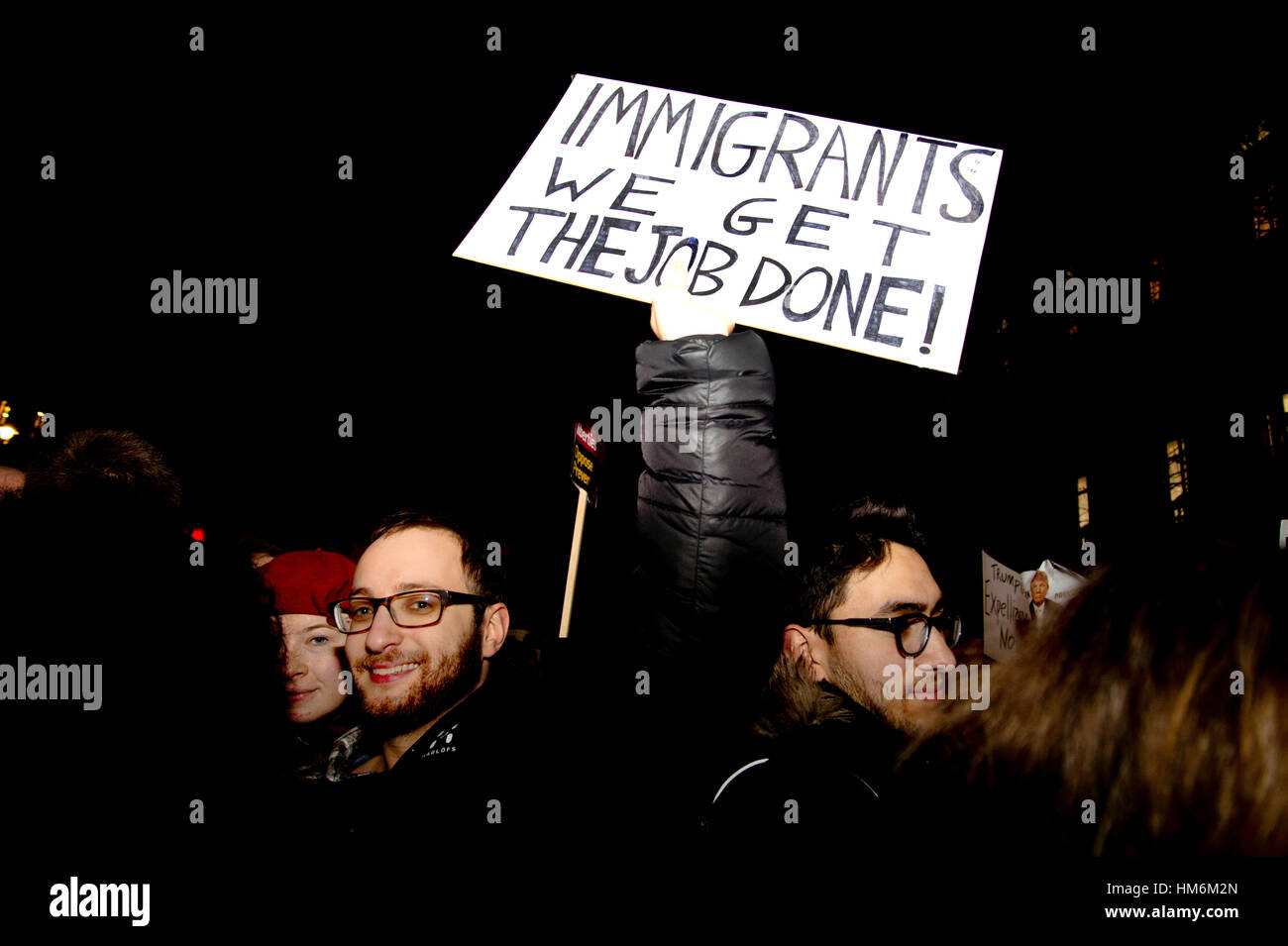 Whitehall. Protest against Donald Trump's travel ban on Muslims. A protester holds a placard saying 'Immigrants, we get the job done'. Stock Photo