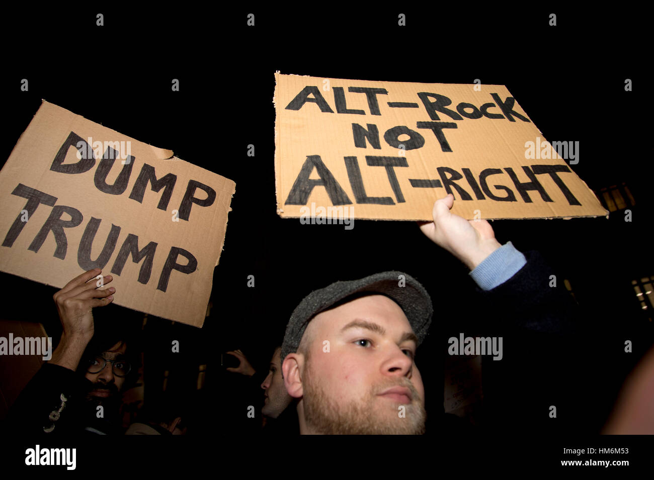 Protest against Donald Trump's travel ban on Muslims. Protesters hold  home-made cardboard signs. One says 'Dump Trump' and another says 'Alt rock' Stock Photo