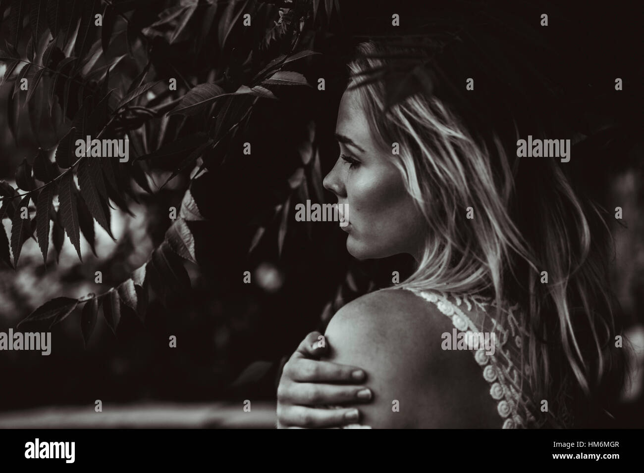 junge Frau steht unter Baum Stock Photo