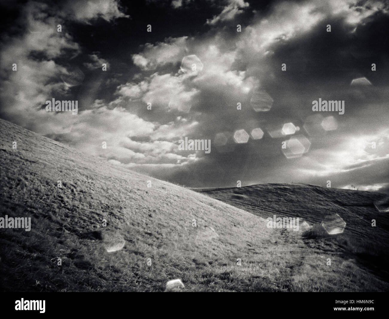 mountain with meadow, clouds and sun, black and white Stock Photo