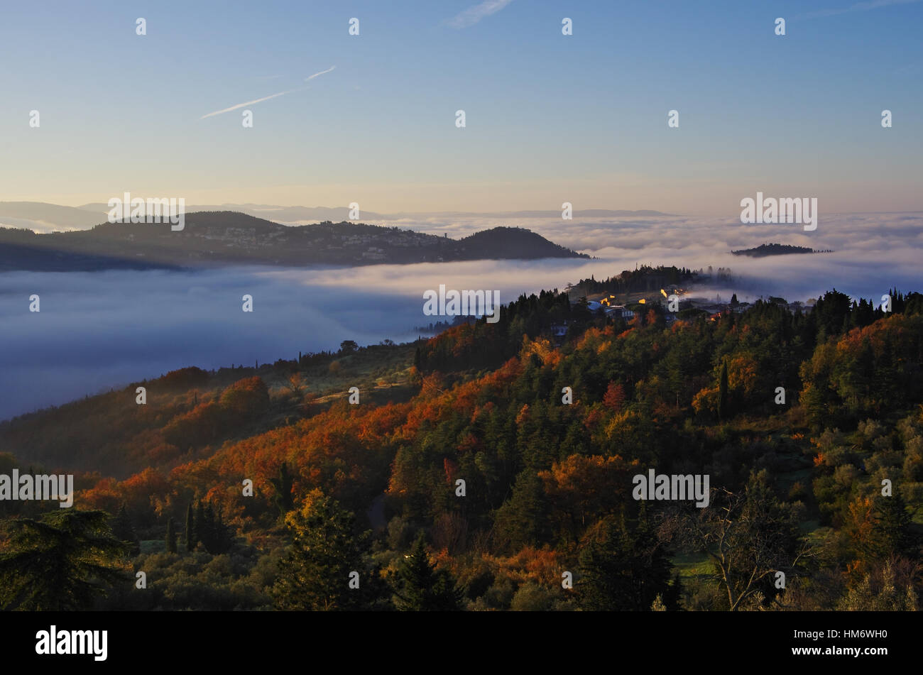 Tuscany hills with autumn colours, fog in the valleys and view of Fiesole. Stock Photo