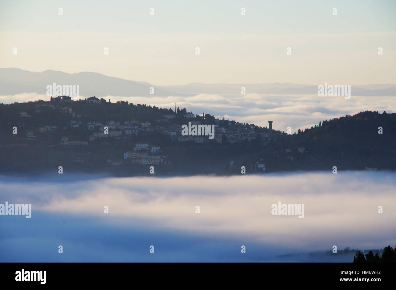 Tuscany hills with autumn colours, fog in the valleys and view of Fiesole. Stock Photo