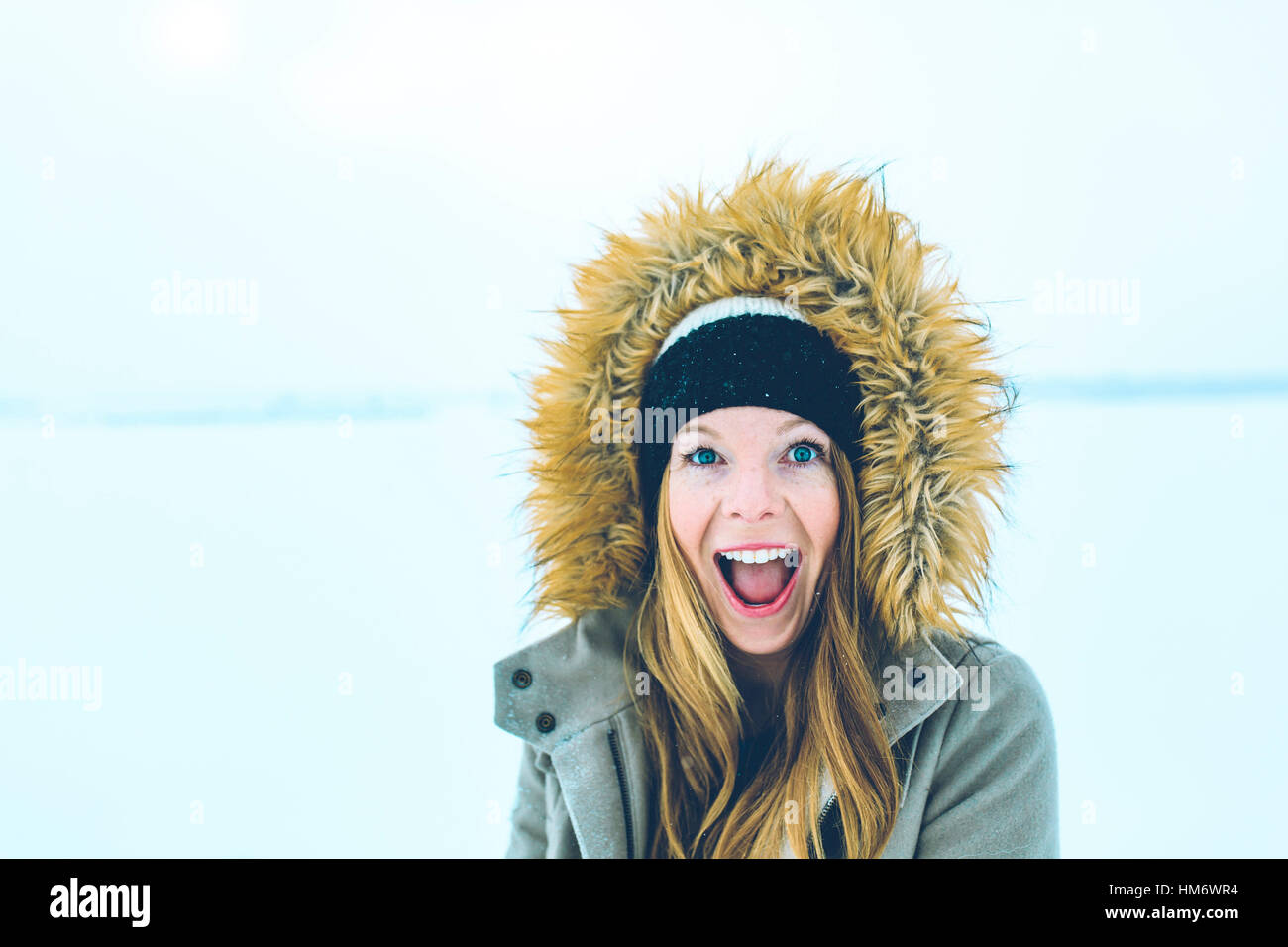 Portrait of woman with mouth open wearing fur hood during winter Stock Photo