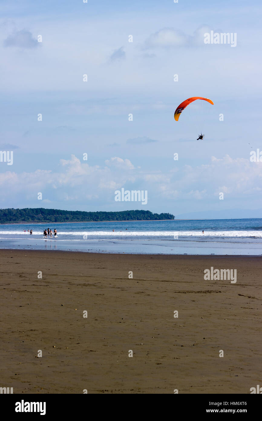 A powered parachute flies above Playa Hermosa at Uvita, Costa Rica. Stock Photo