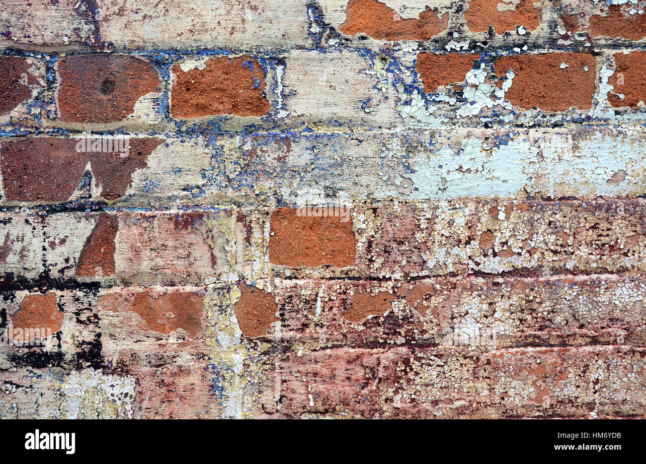 Old cracked rendered wall from historic building with exposed brick and mortar and peeling paint. Grunge texture background Stock Photo