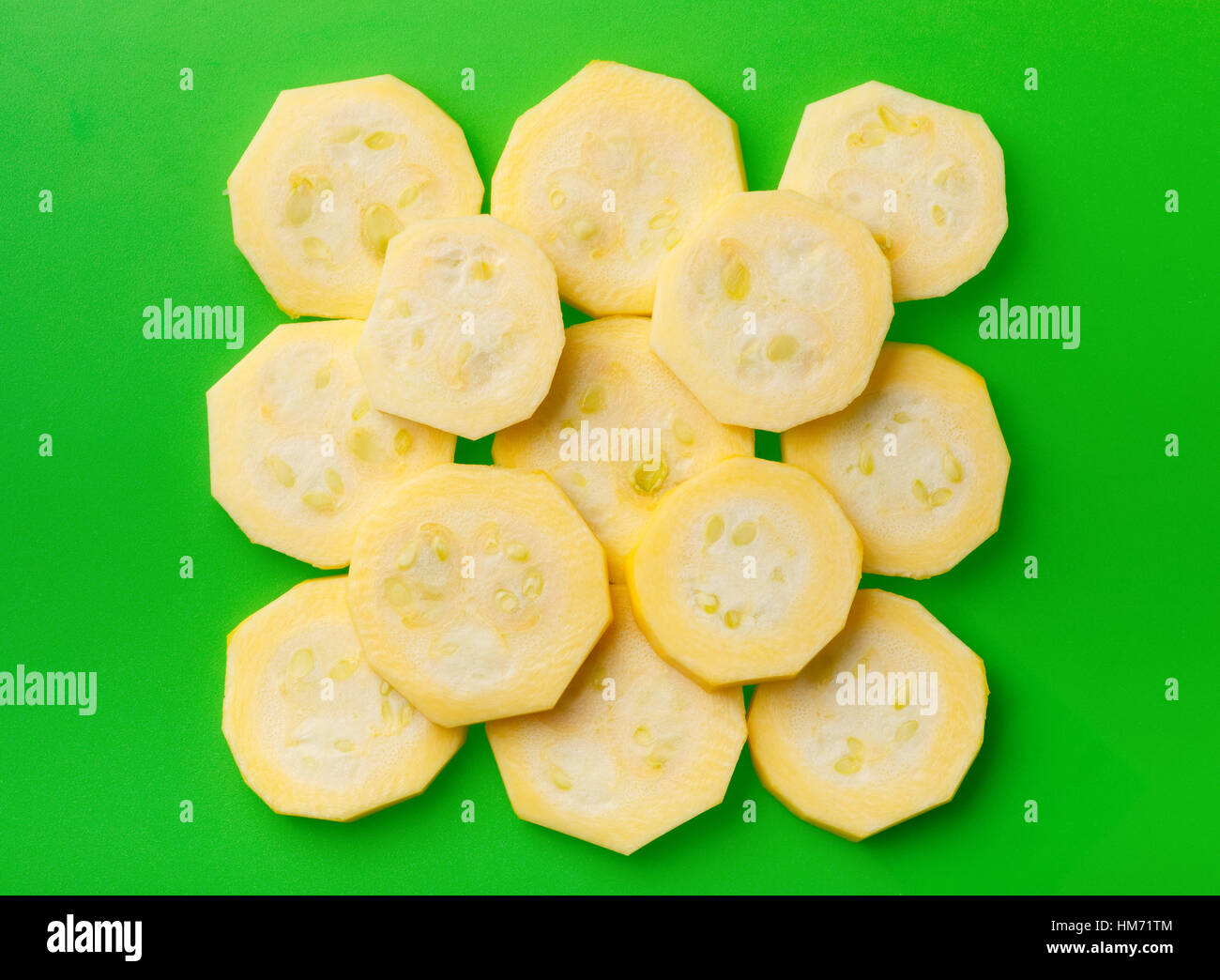 Zucchini sliced by rings folded in the form of a square to each other on green cutting board Stock Photo