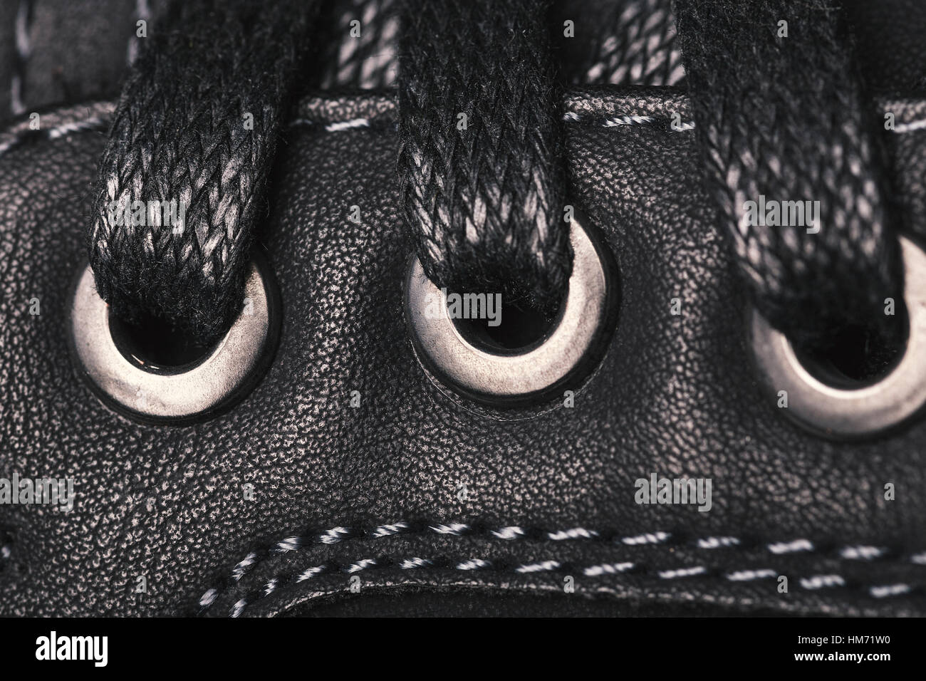 Macro picture of a part of a black men's boot. In the photo a part with ...