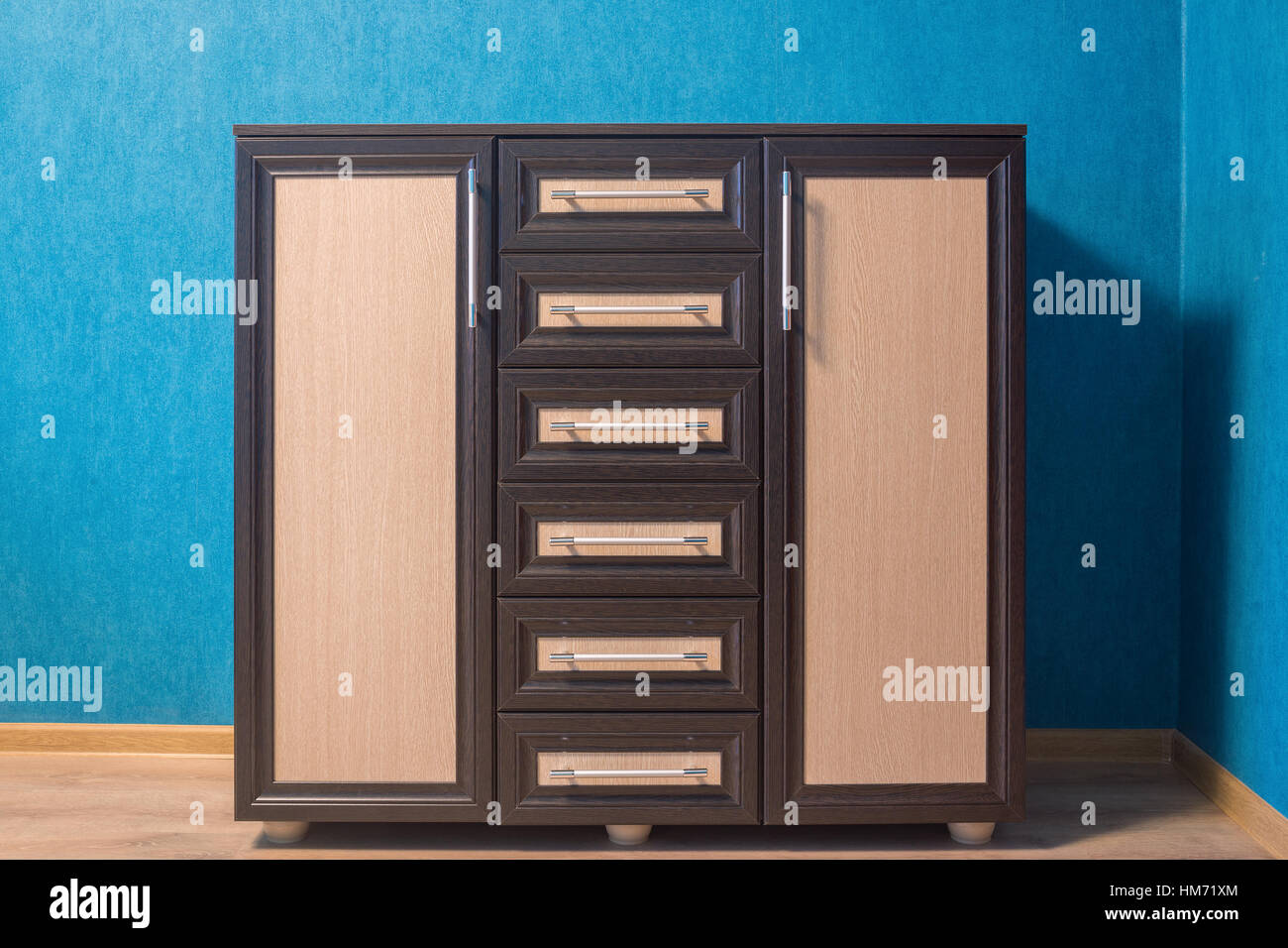 The brown dresser with beige inserts is photographed in an interior