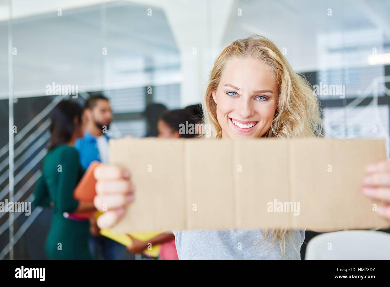 Woman holding blank sign in start-up office Stock Photo