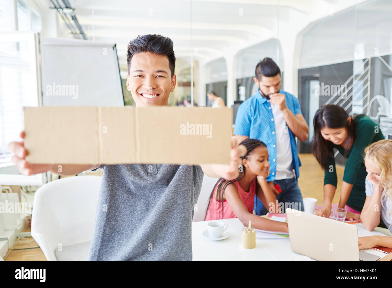 Creative brainstorming in workshop and man holding blank sign Stock Photo
