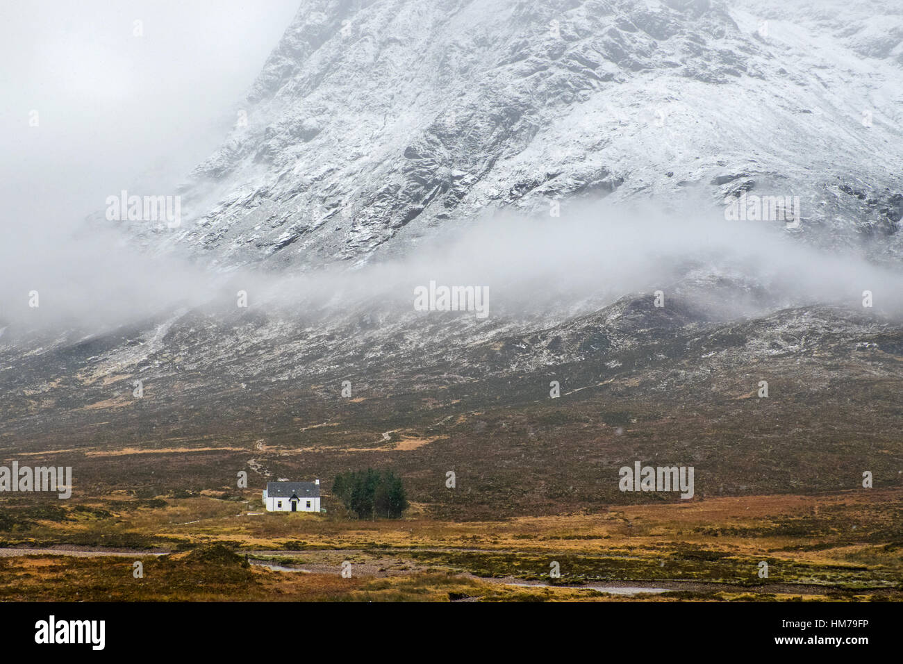 Scottish cottage beneath a snowy mountain side near Glencoe,Scotland Stock Photo