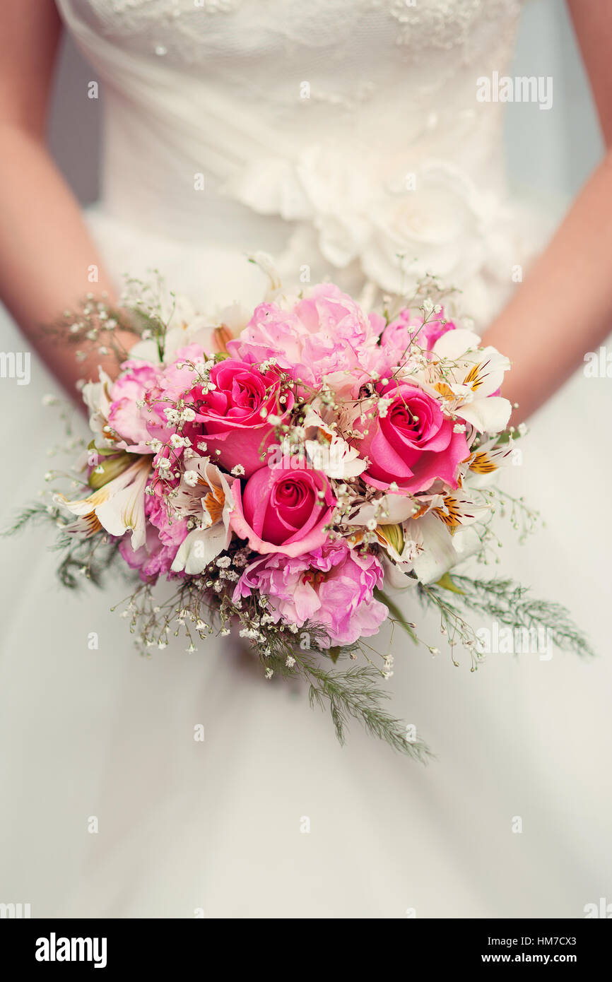 Bride holding wedding bouquet of roses Stock Photo - Alamy