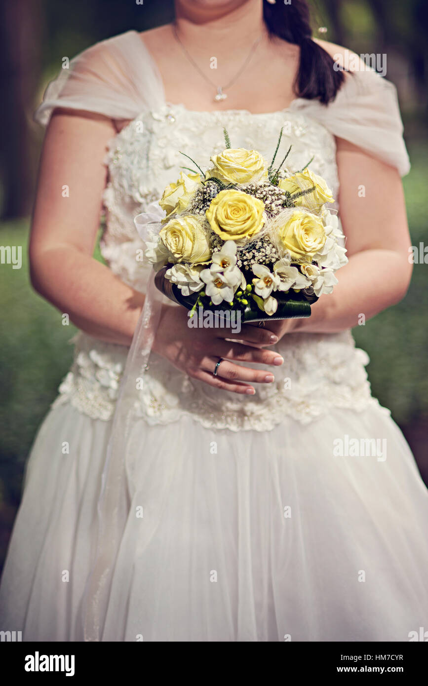 Bride holding wedding bouquet of roses Stock Photo - Alamy