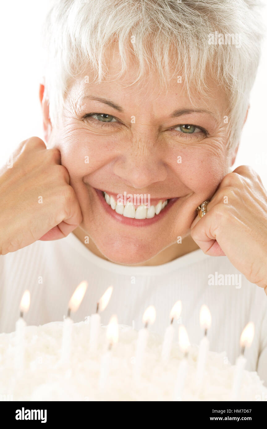 Smiling mature woman with birthday cake Stock Photo