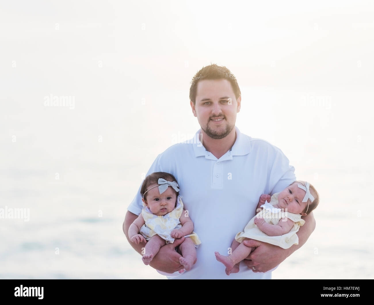 Happy father holding babies (25 months Stock Photo Alamy