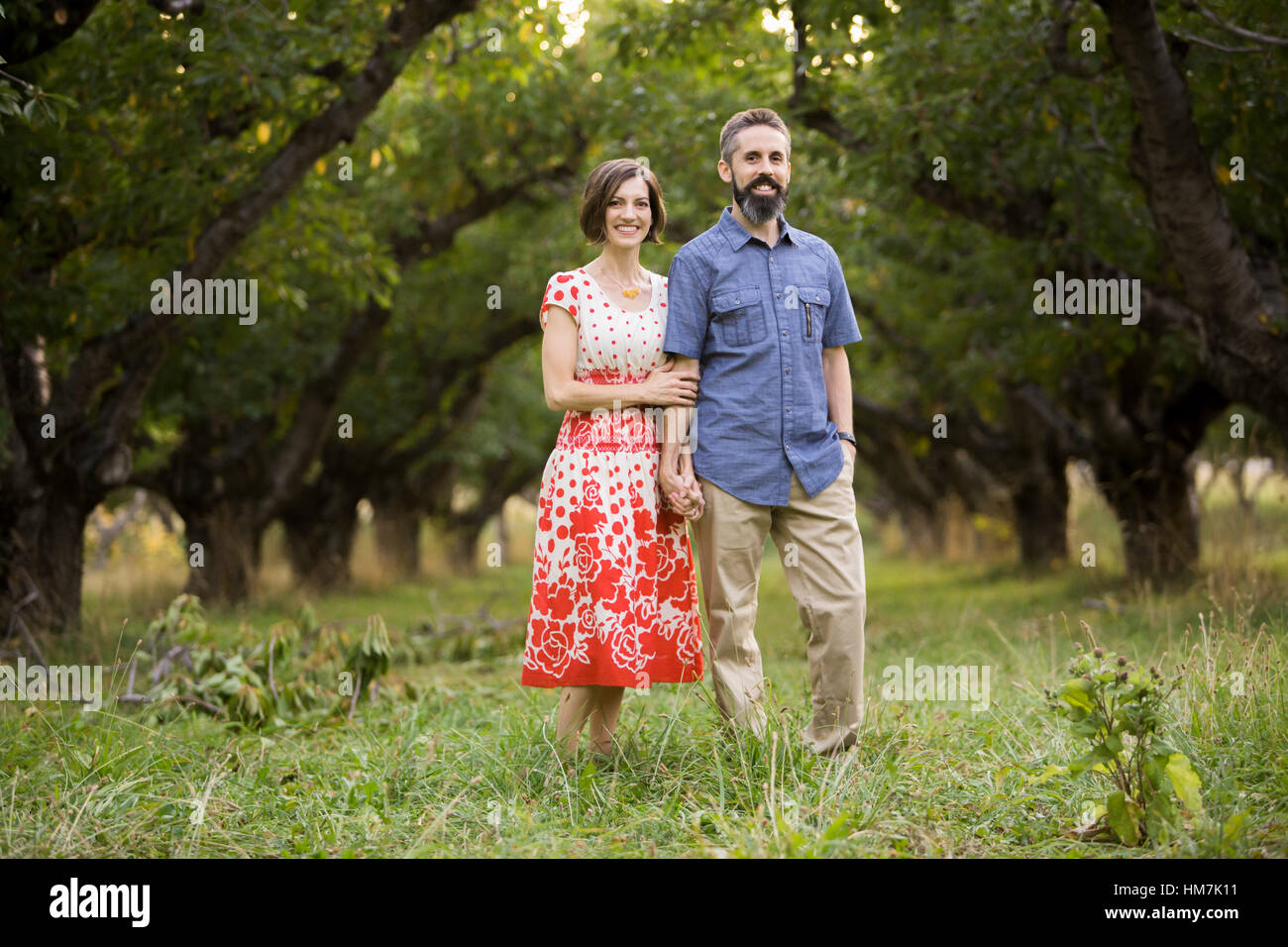 Couple walking in cherry orchard Stock Photo