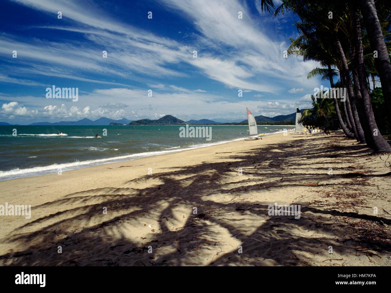 Palm trees and sail boats on the beach at Palm Cove near Port Douglas