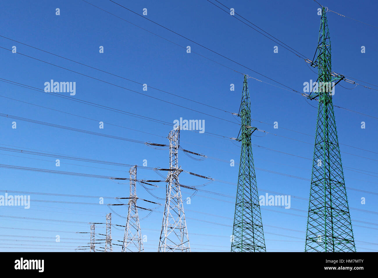 high voltage electric towers under blue sky Stock Photo - Alamy