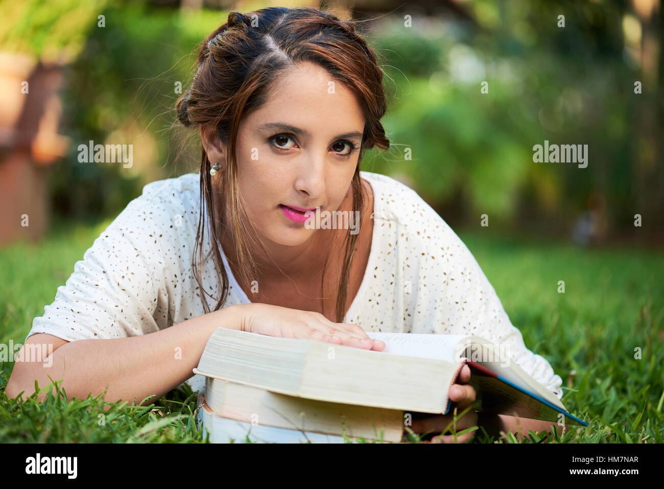girl laying down with books at the park Stock Photo Alamy
