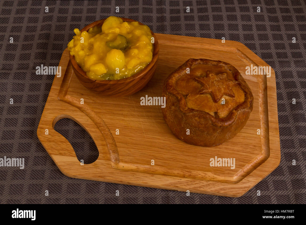 Piccalilli relish in a wooden bowl on a board. Stock Photo