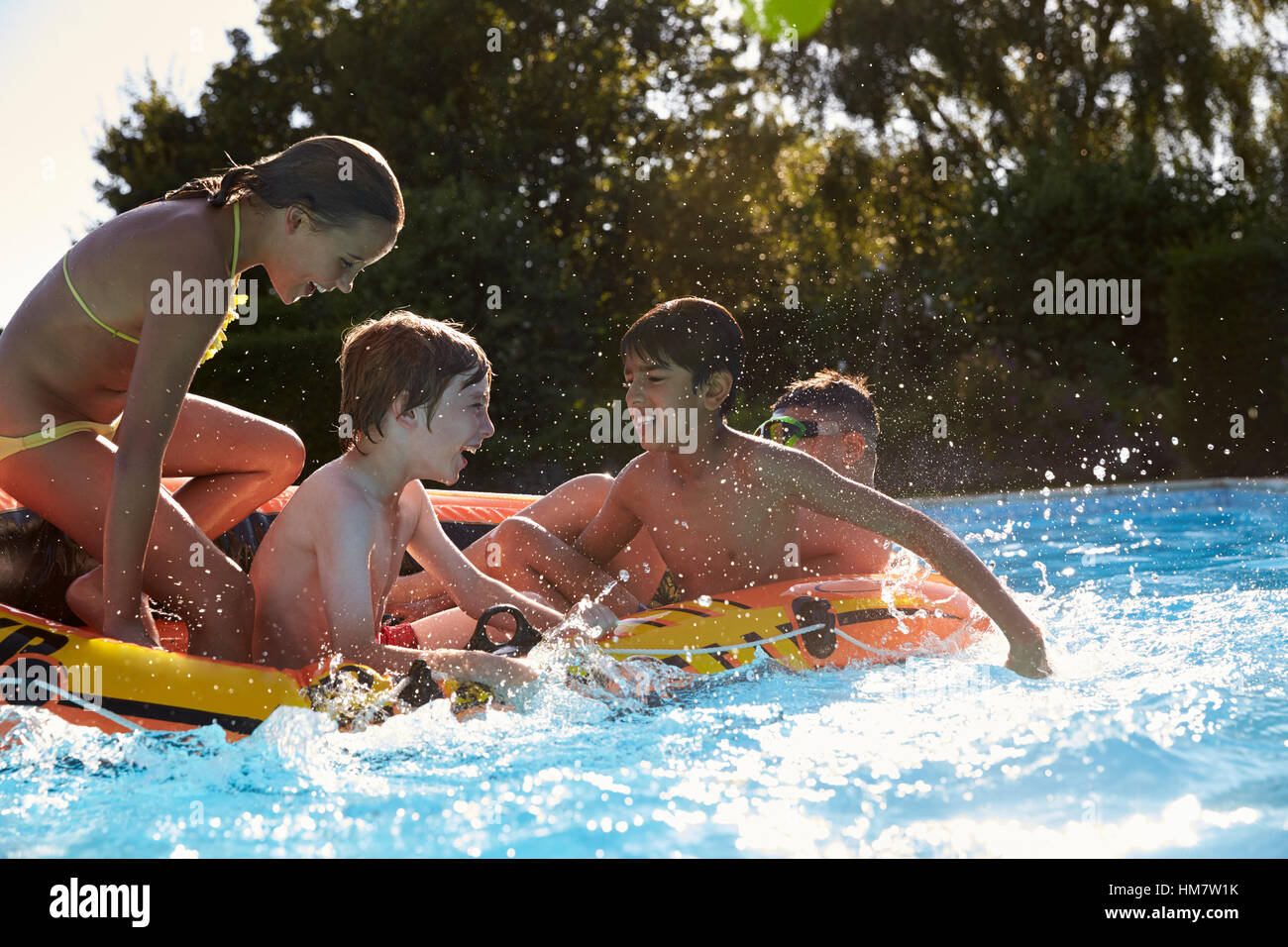 Children Having Fun On Inflatable In Outdoor Swimming Pool Stock Photo