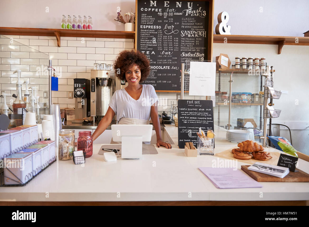 Smiling waitress behind the counter at a coffee shop Stock Photo