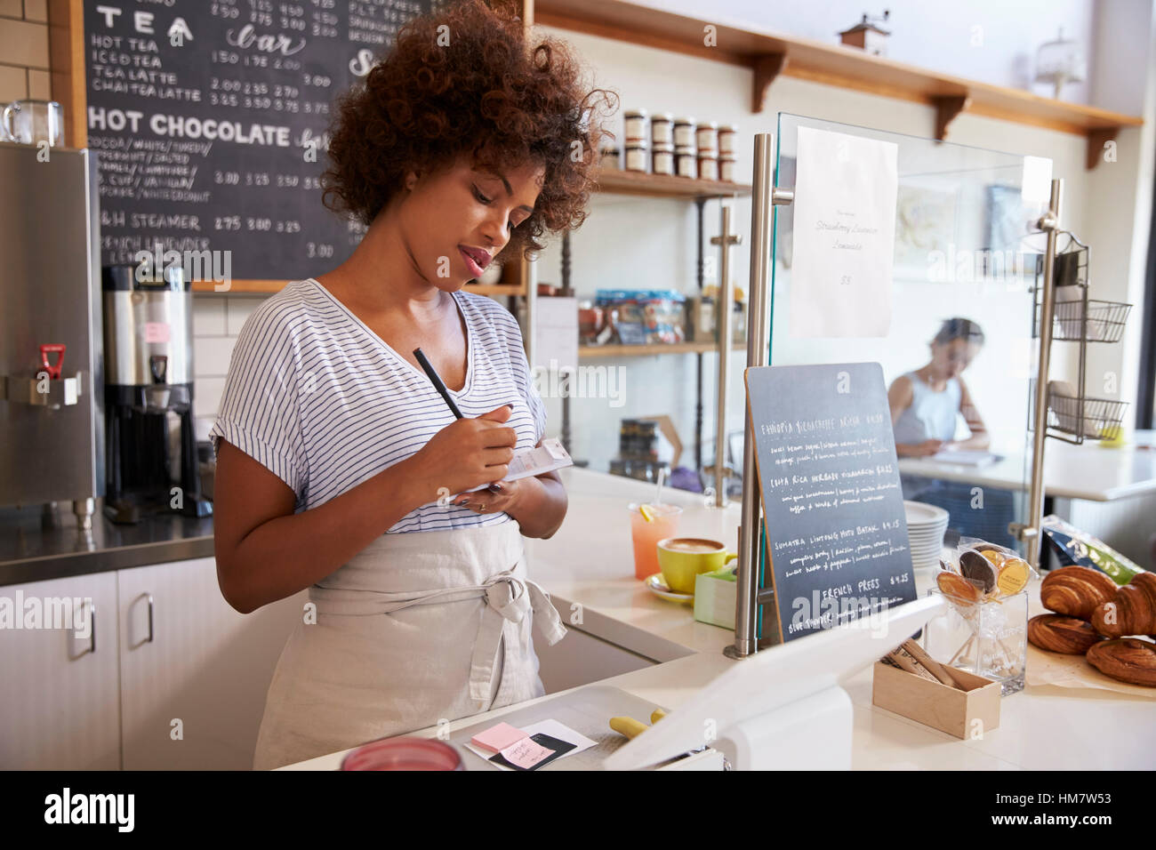 Waitress writing down an order at a coffee shop, close up Stock Photo