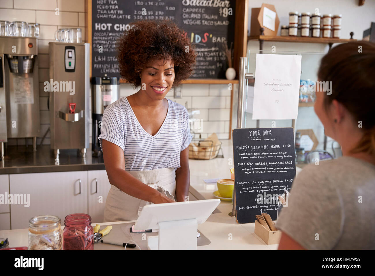 Waitress taking a customer’s order at till in a coffee shop Stock Photo