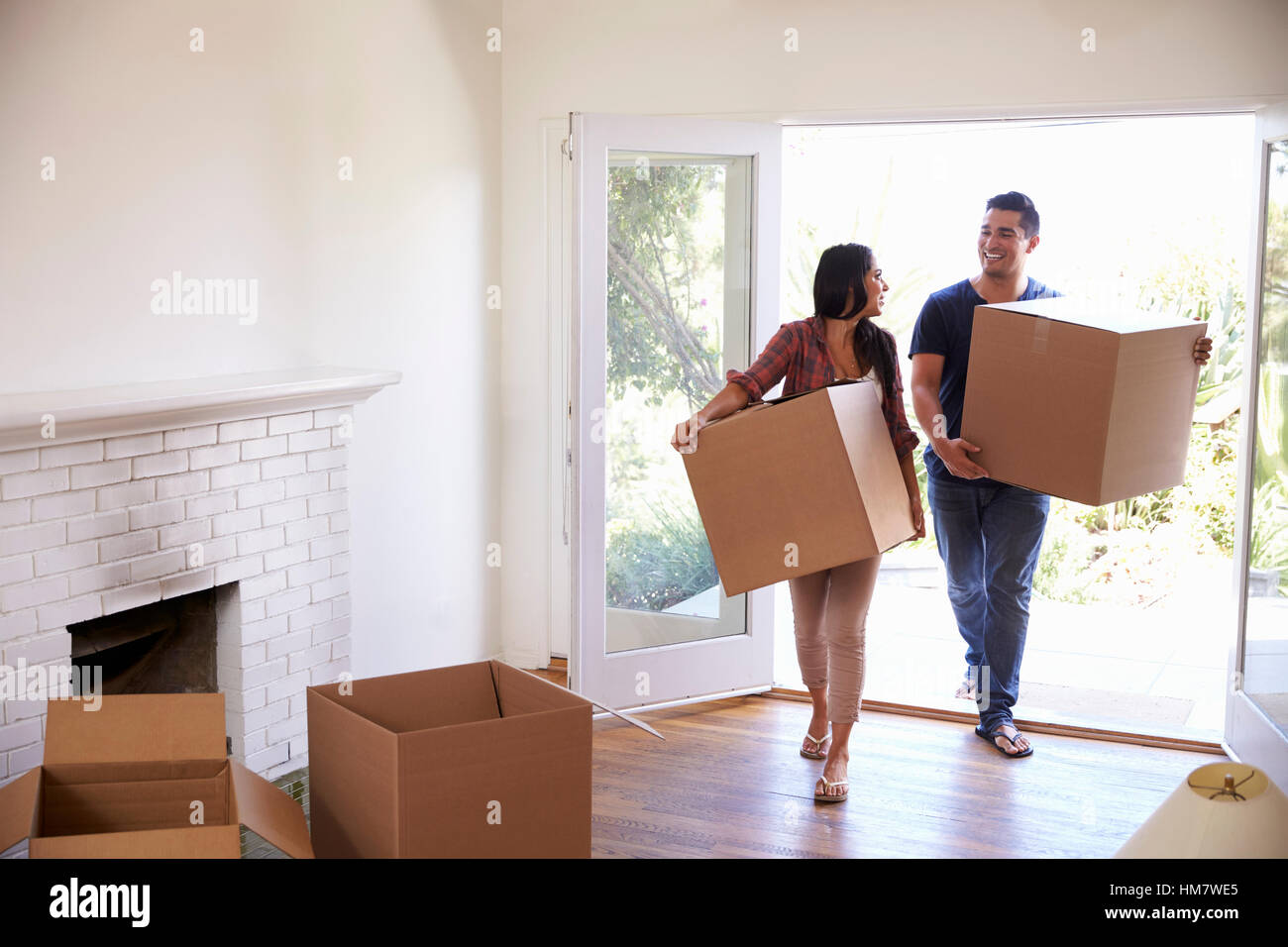 Couple Carrying Boxes Into New Home On Moving Day Stock Photo - Alamy