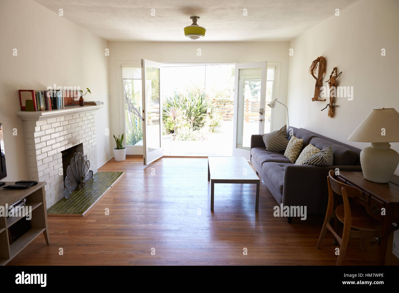 Interior Of Modern Lounge With Open French Windows To Garden Stock Photo
